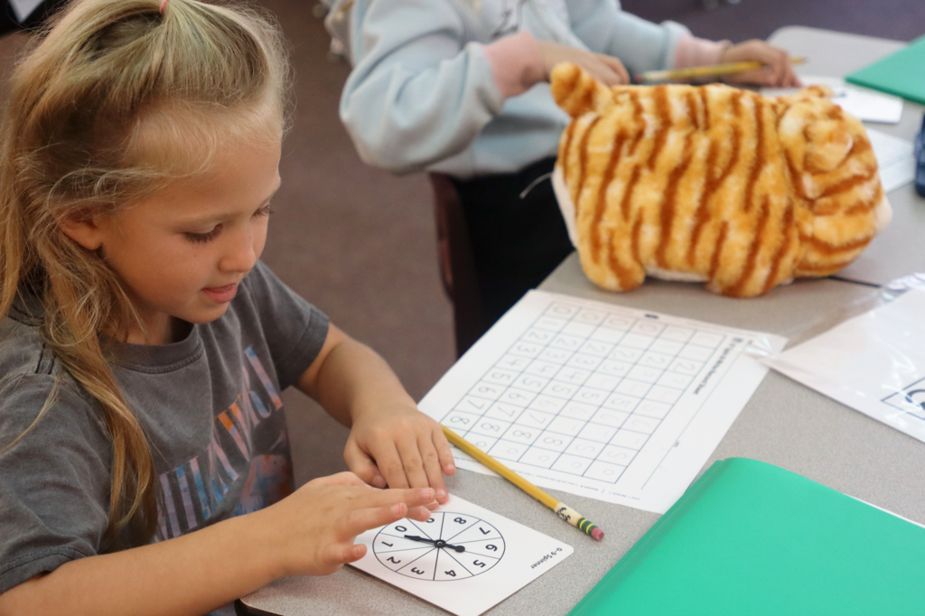little girl spinning a wheel with numbers on it