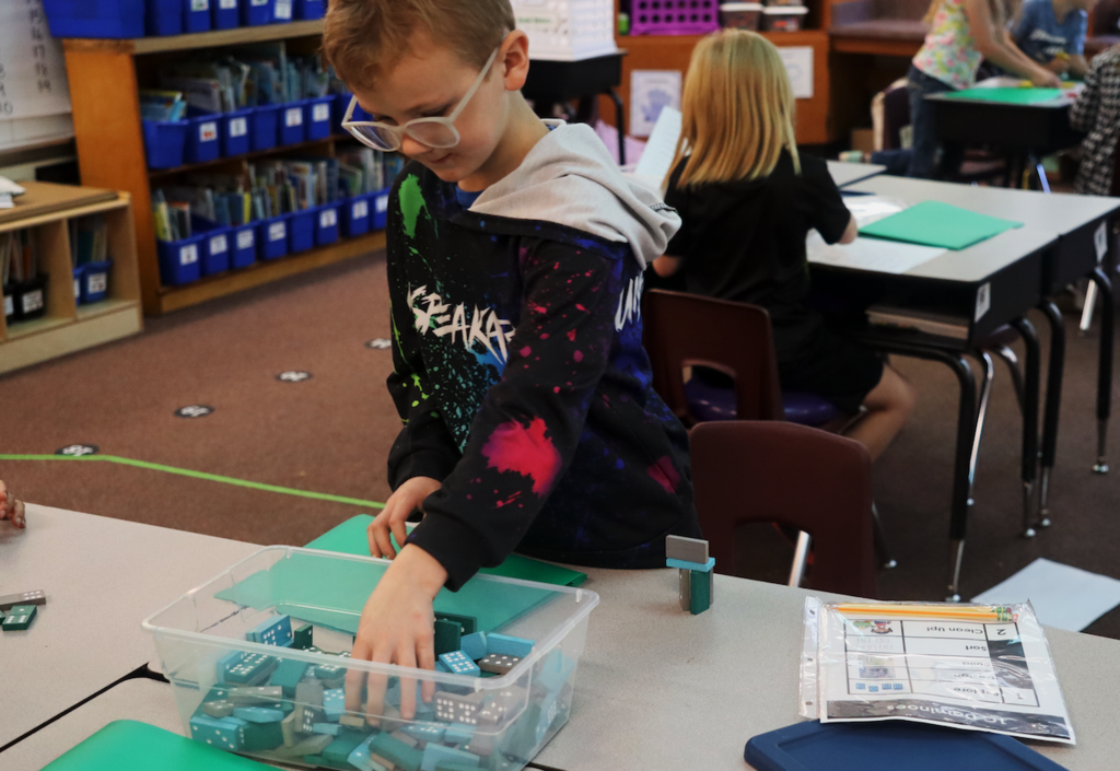 little kid building with dominoes