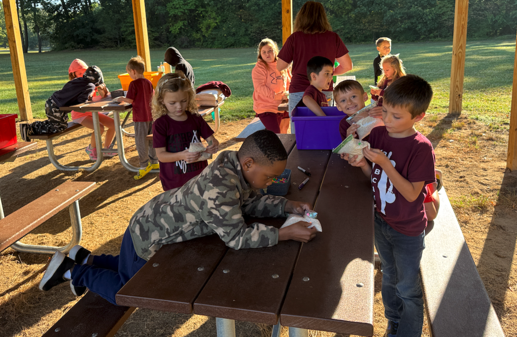 kids at table with bags of rice