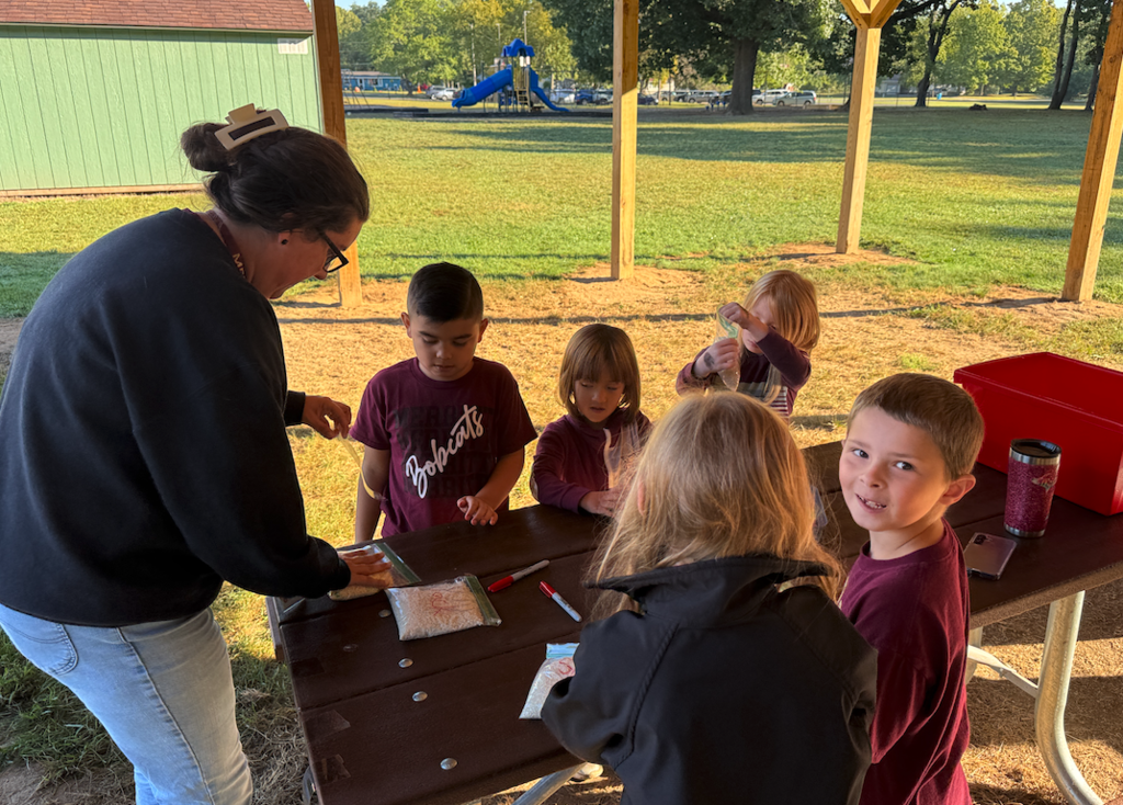 kids sitting at table with bags of rice