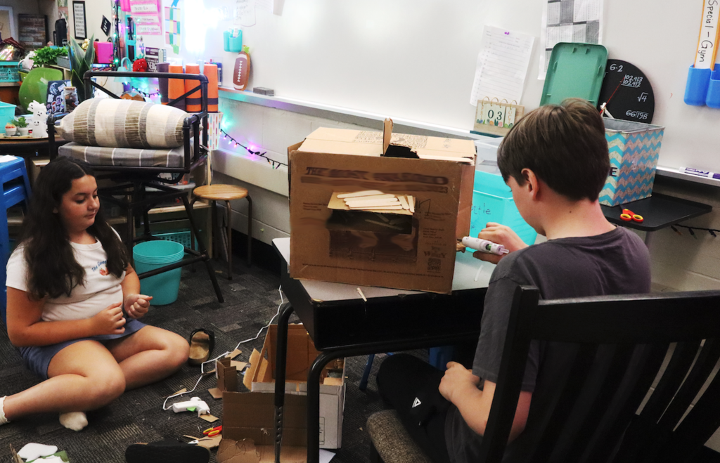 students flying onto cardboard box