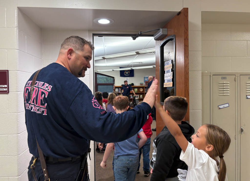 firefighter high fiving a child