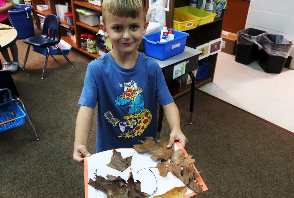 little boy holding leaf man