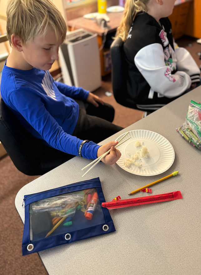 student eating with chopsticks