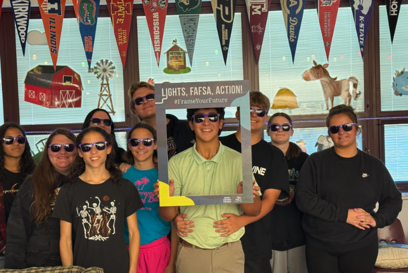 students standing with sunglasses on and FAFSA cut out