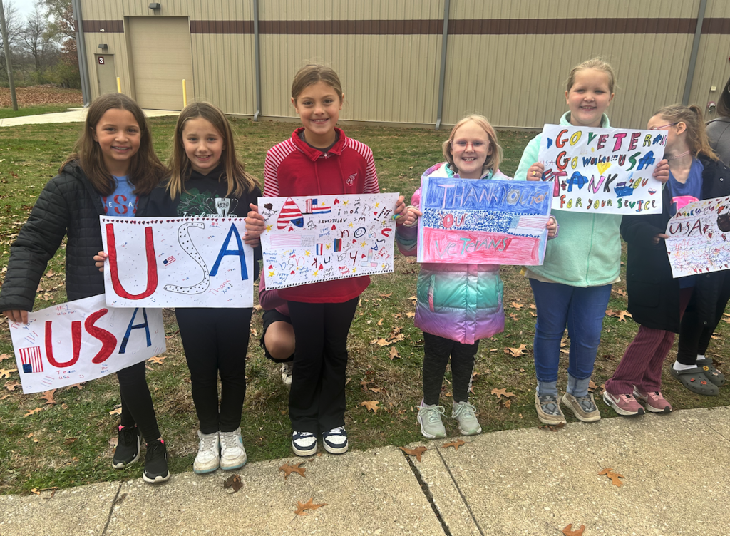 kids holding veterans signs