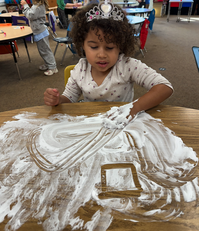 little girl drawing in shaving cream