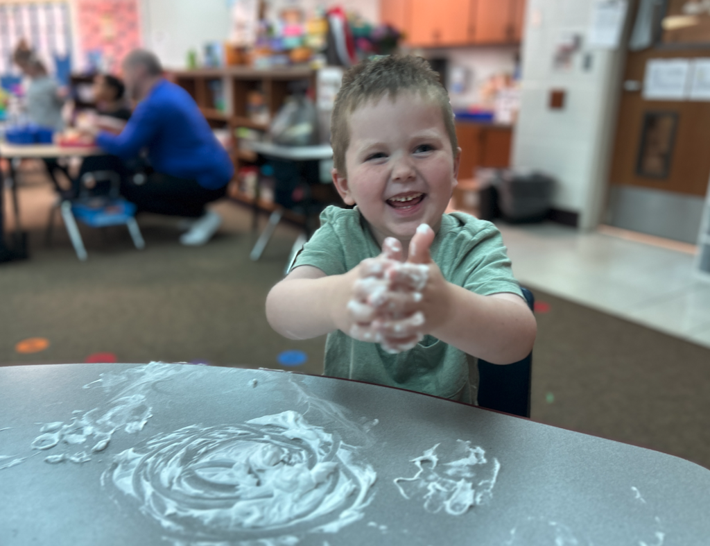 little boy with shaving cream on his hands