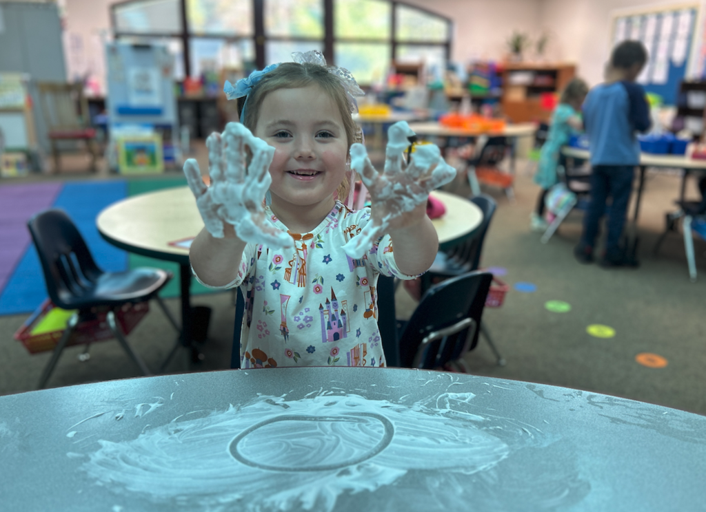 little girl with shaving cream on her hands