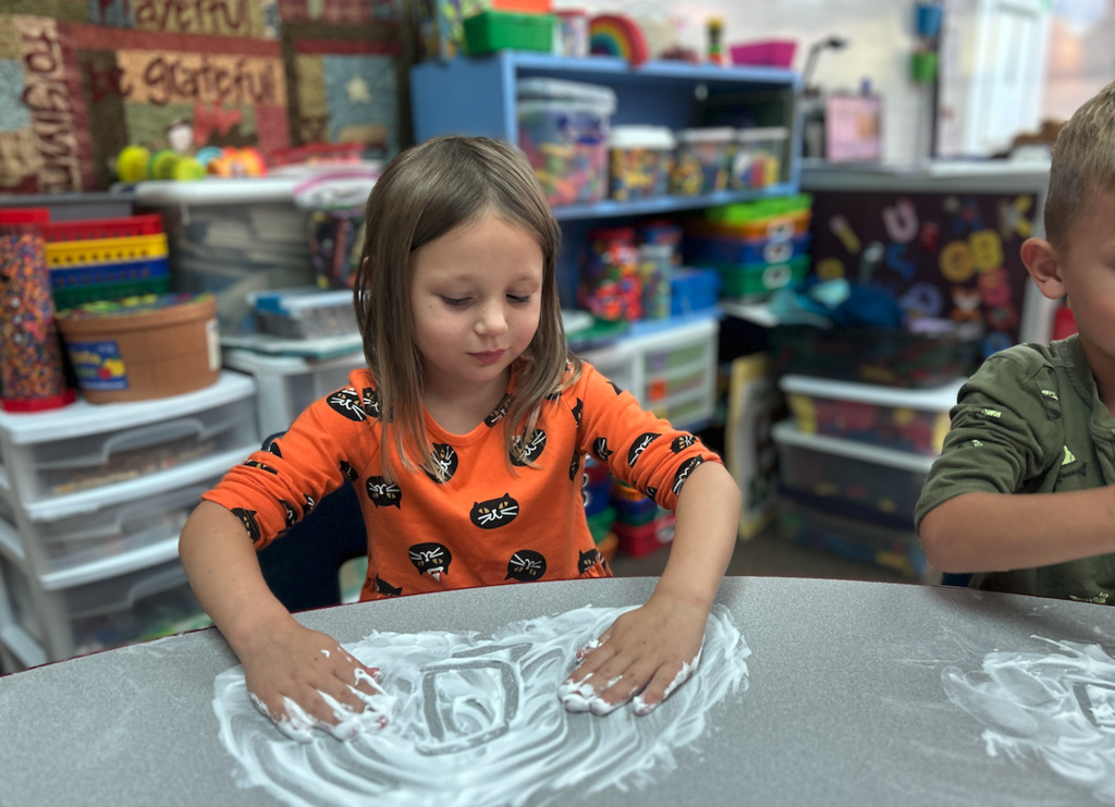 little girl with shaving cream on her hands