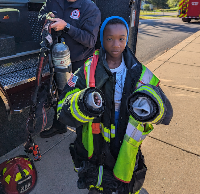 kid dressed in firefighters uniform