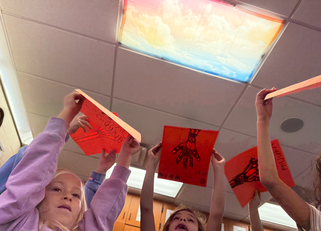 kids holding up paper