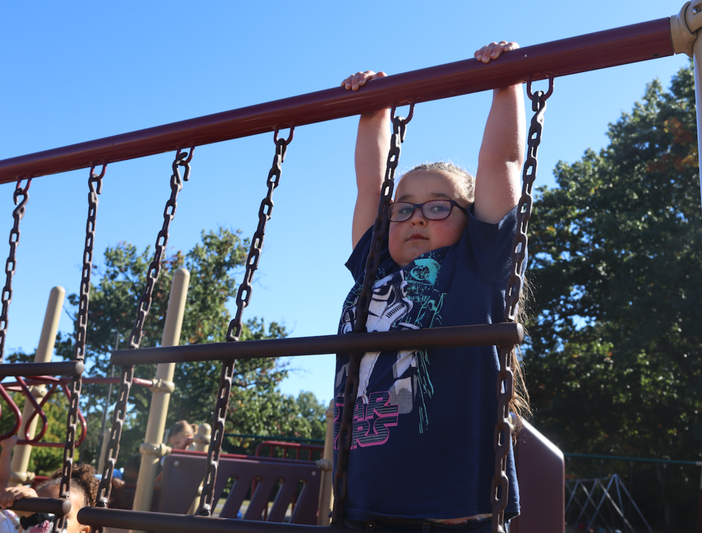 little girl climbing the monkey bars