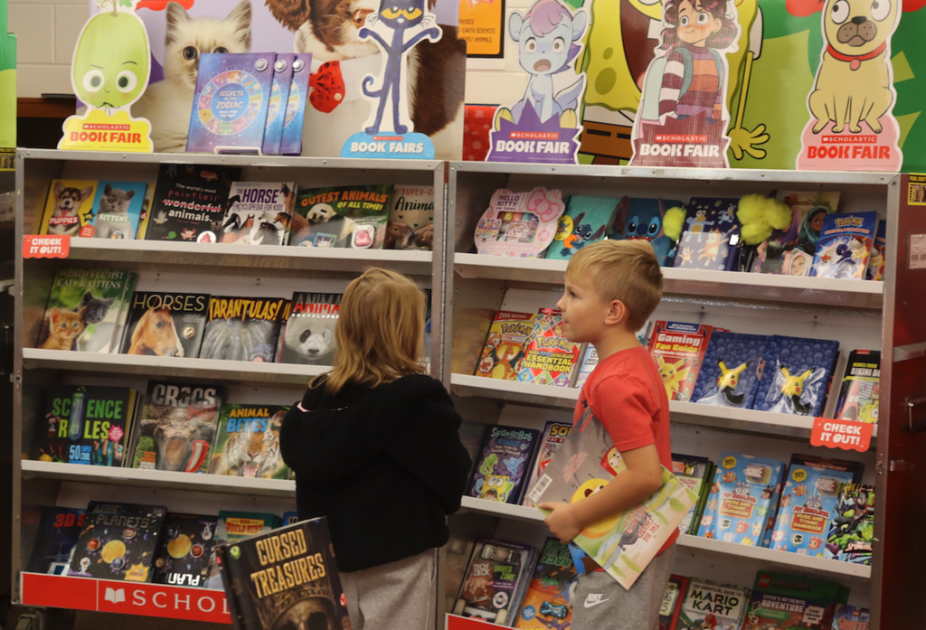 little boy and little girl looking at books at book fair