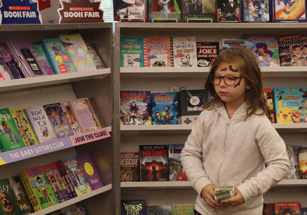 little girl with money at book fair