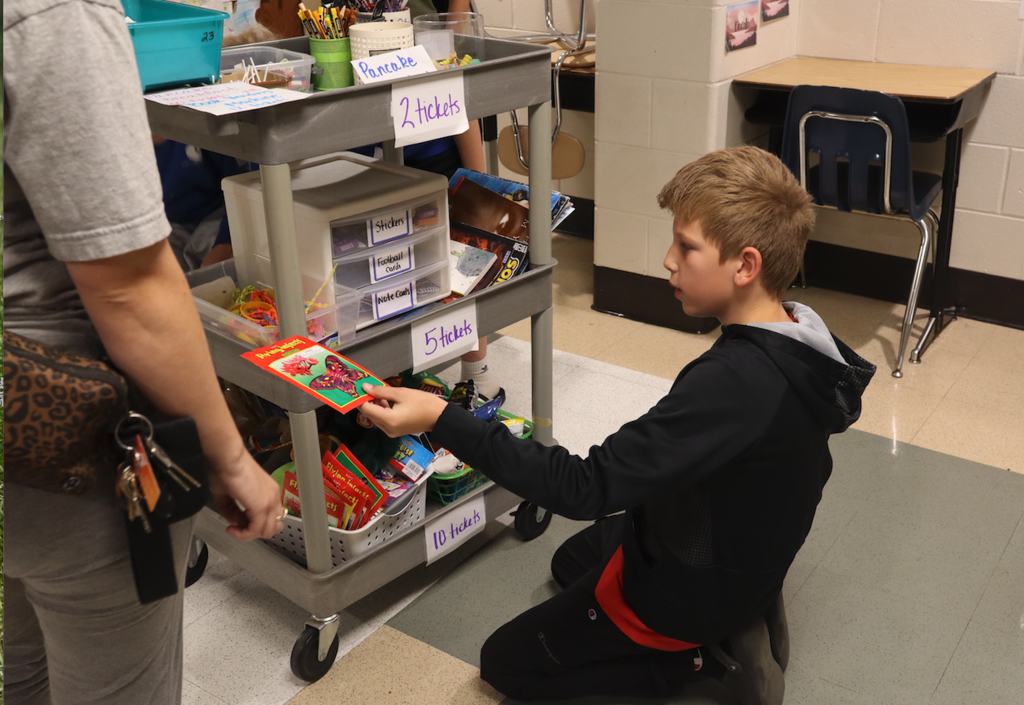 boy picking out item from car