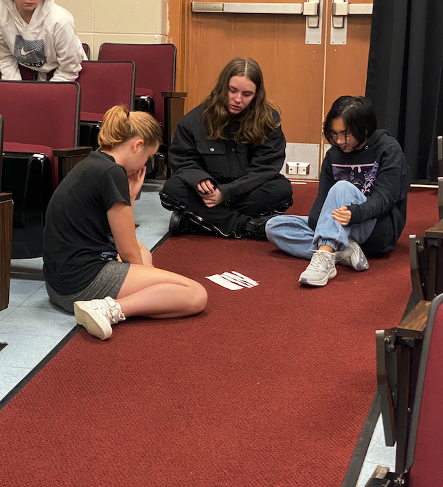 group of students sitting on lecture hall floor