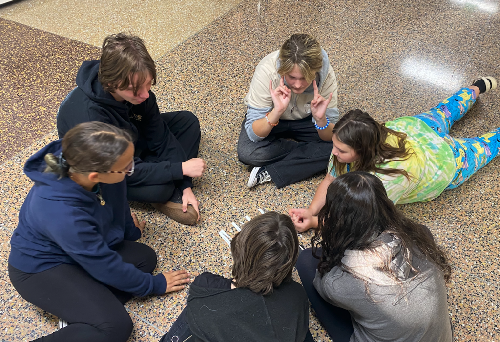 group of students sitting in the hallway
