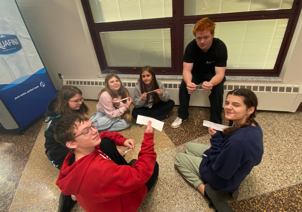 group of students sitting in the hallway