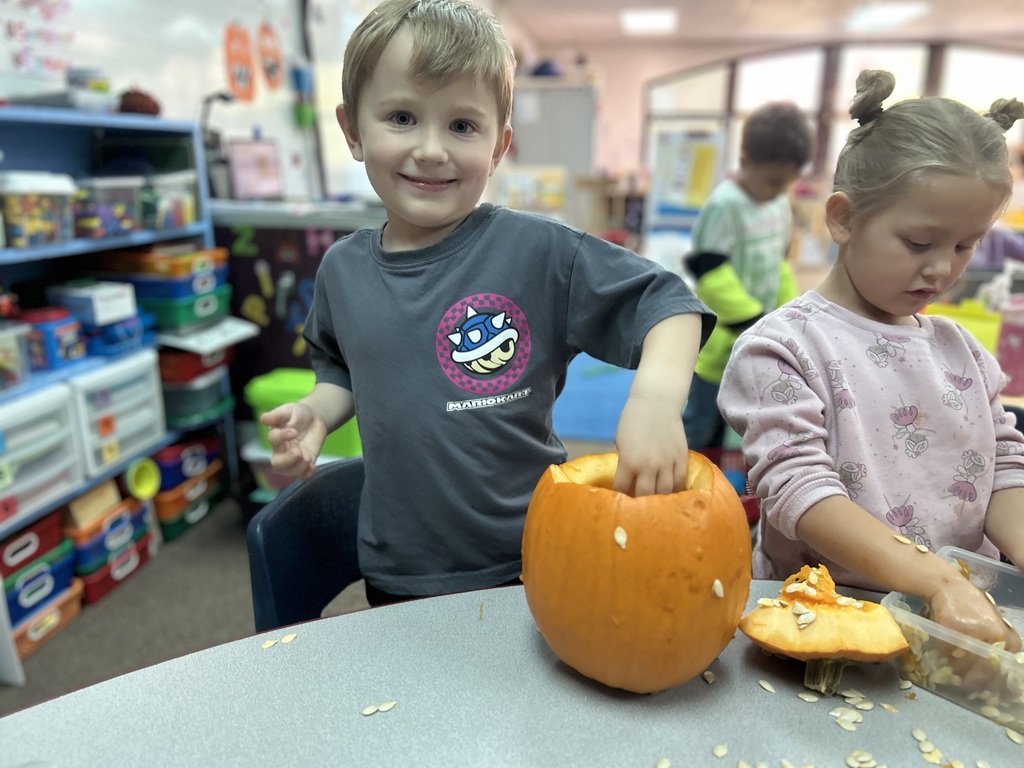 little boy cleaning out pumpkin