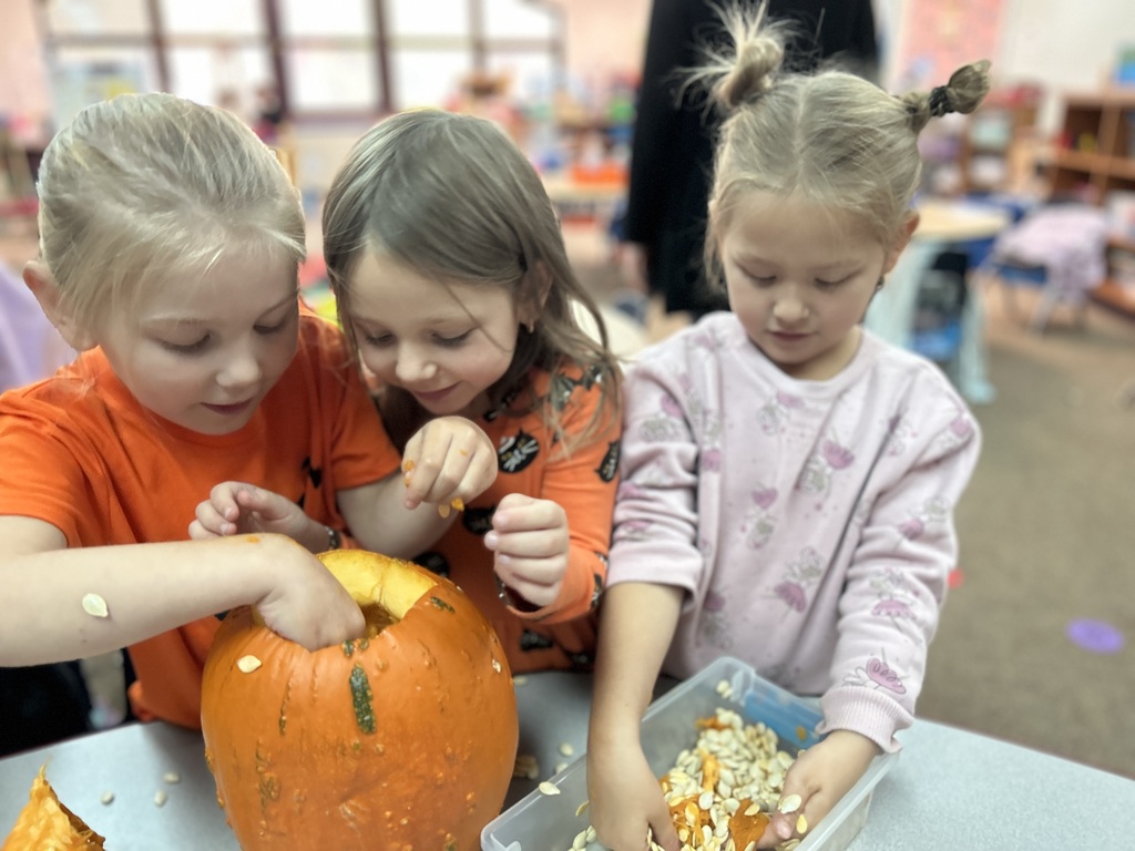 little girls cleaning out pumpkin