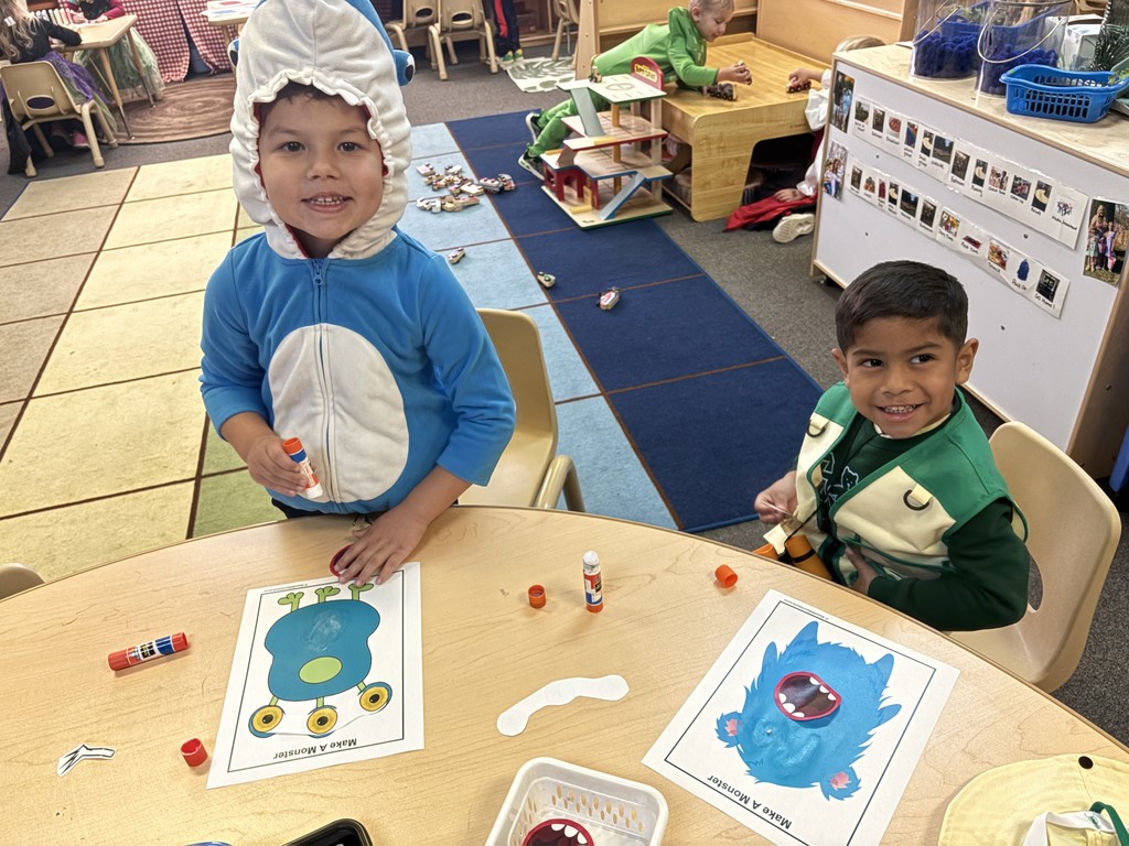 two little boys playing a game at table in costumes