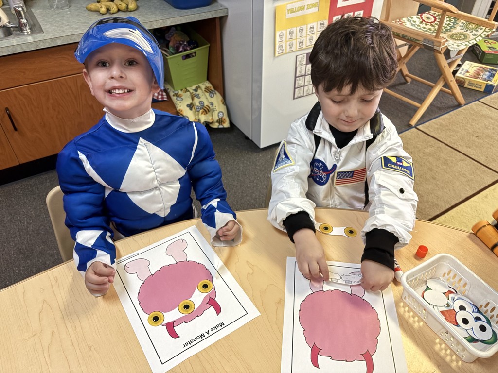 two little boys playing a game at table in costumes
