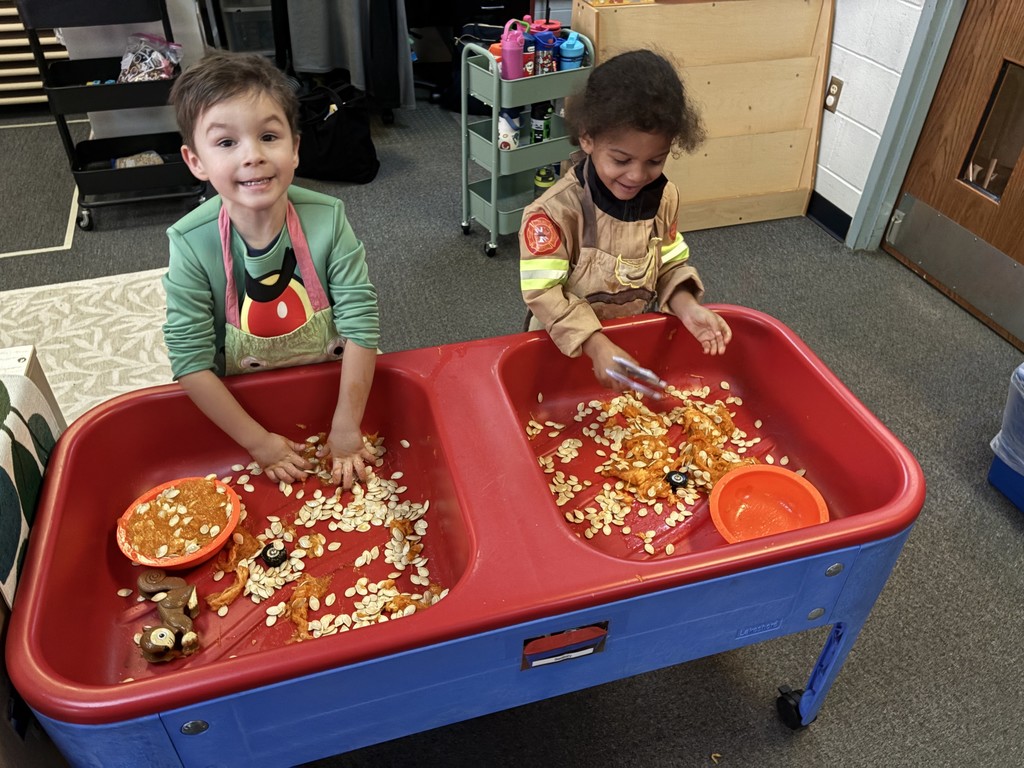 two little boys playing with pumpkin seeds