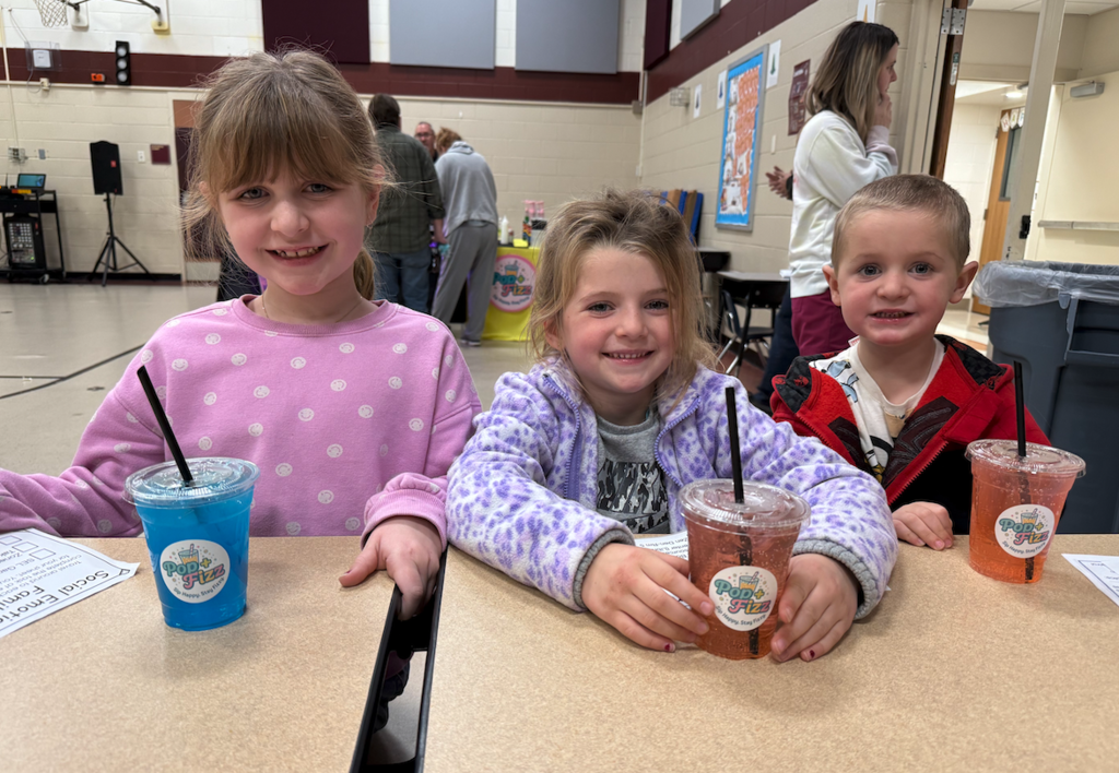 three kids sitting at a table