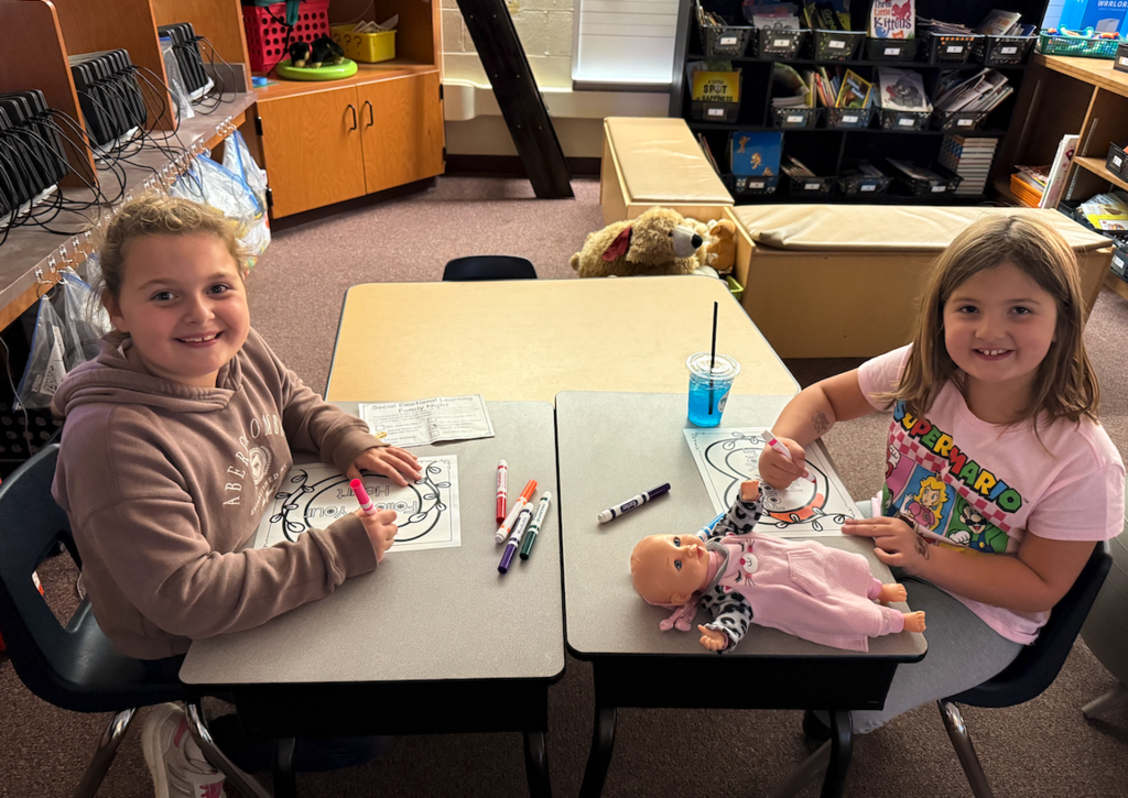 two kids sitting at tables