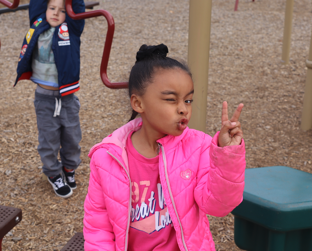 little girl giving the peace sign