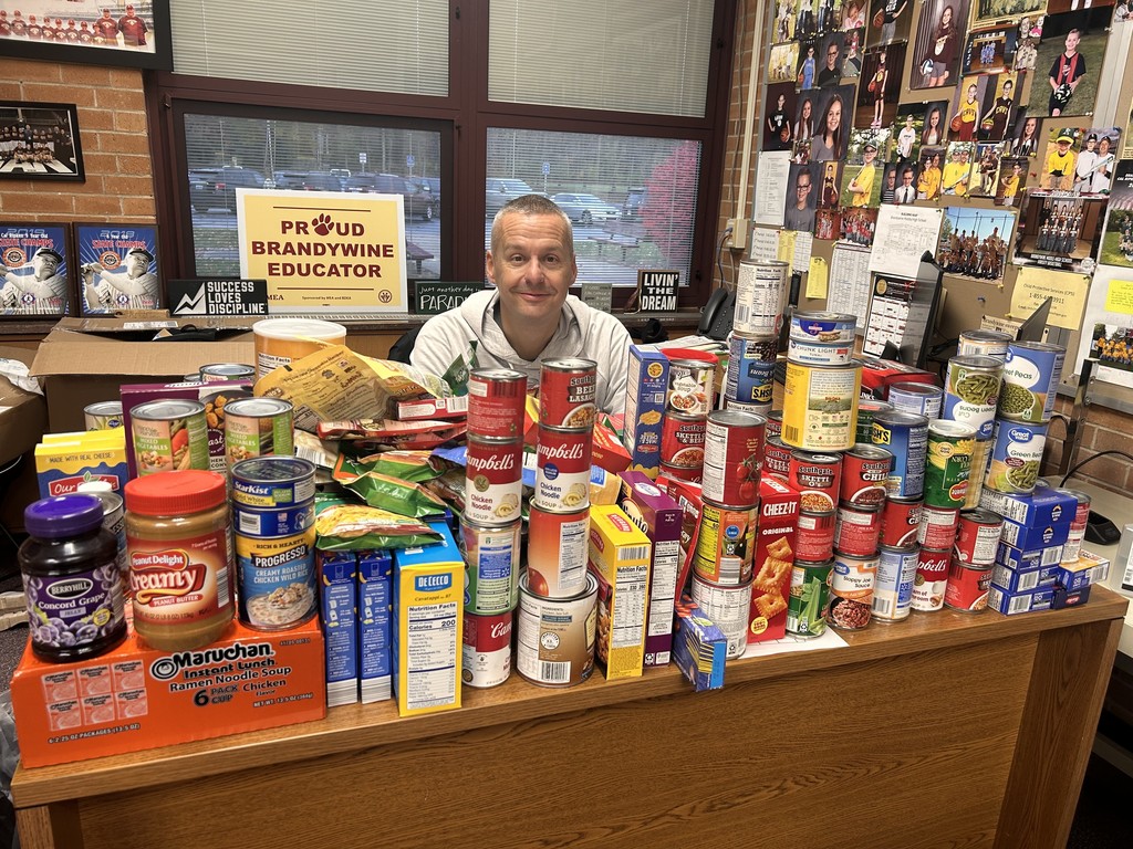mr hood at his desk with a bunch of food cans