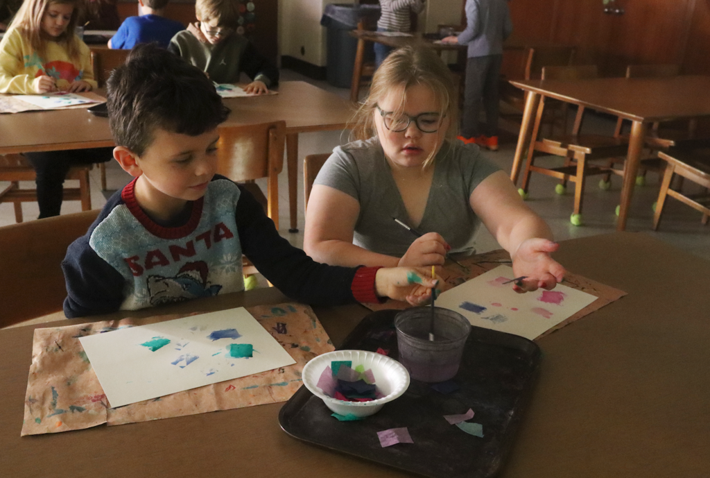 a little girl and a little boy working on their art project