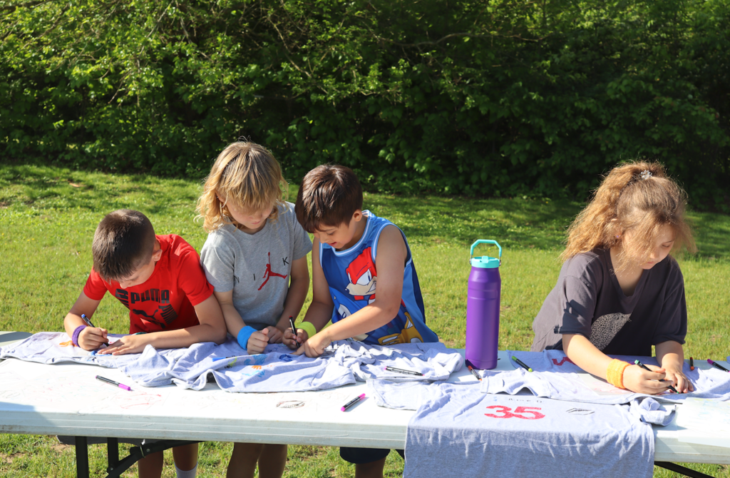 kids drawing on t shirts at field day