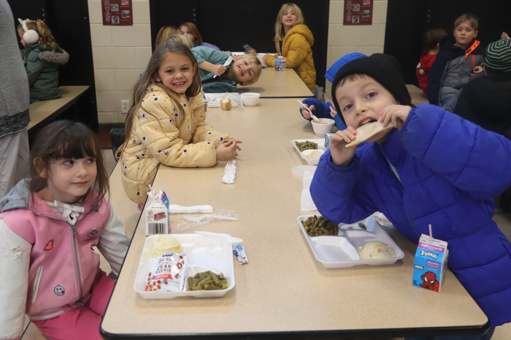 little kids at table eating lunch 