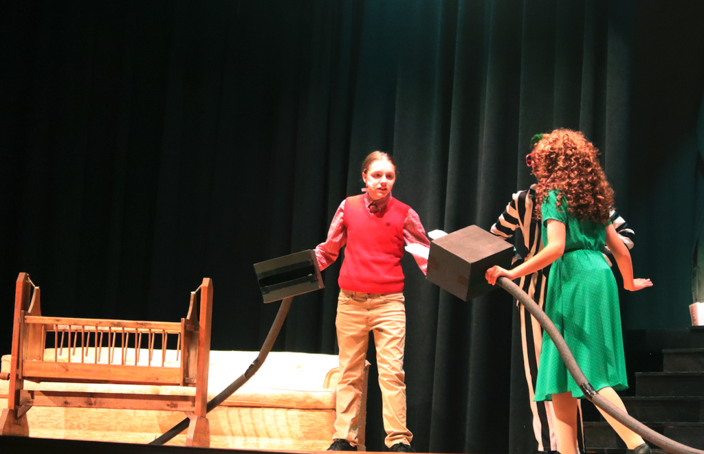 two students singing together on stage