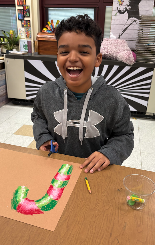 little boy drawing candy cane laughing