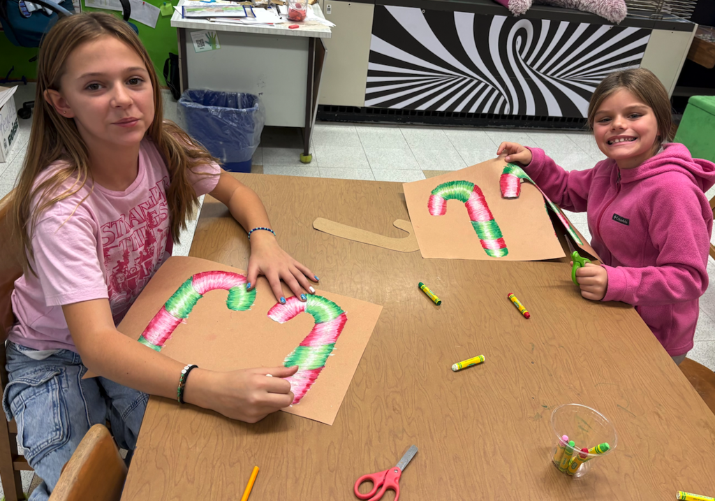 two girls drawing candy canes