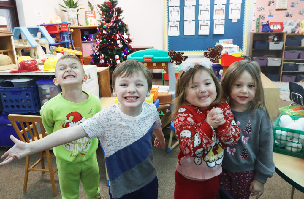 two little girls and two little boys smiling at camera