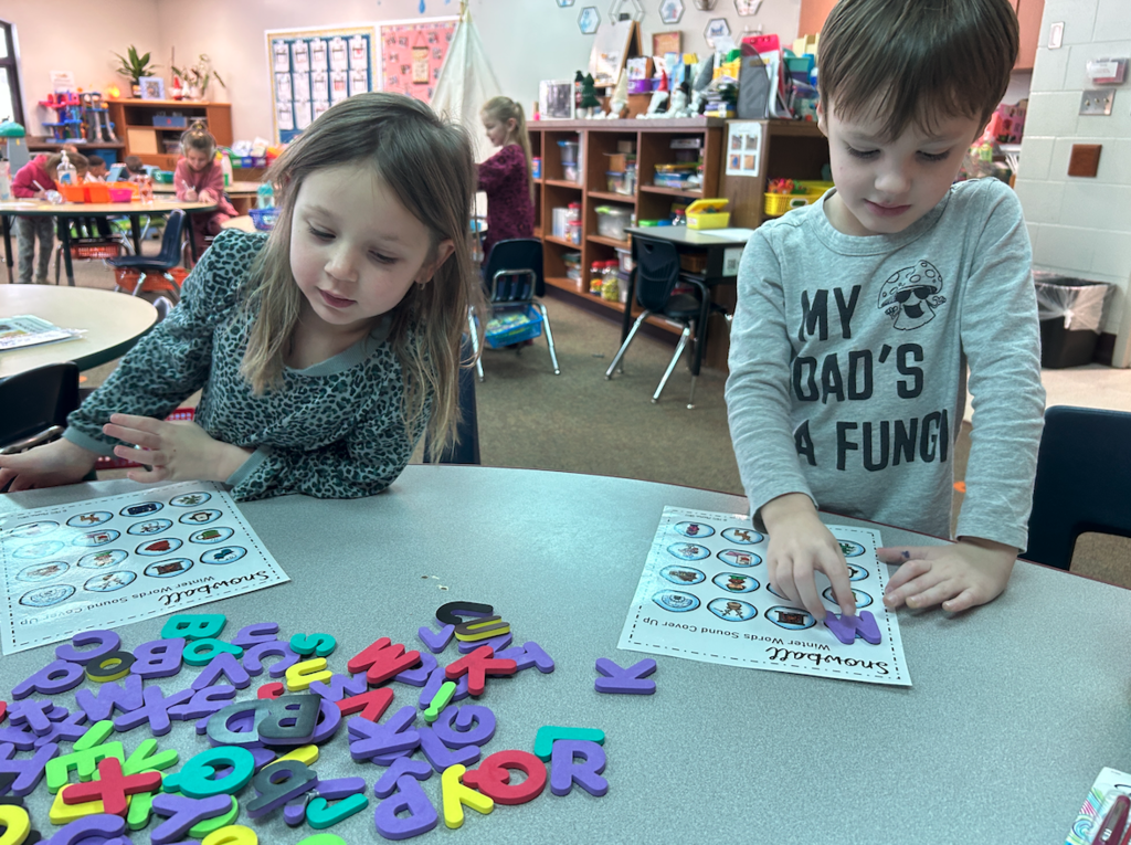 a little girl and little boy playing with letters