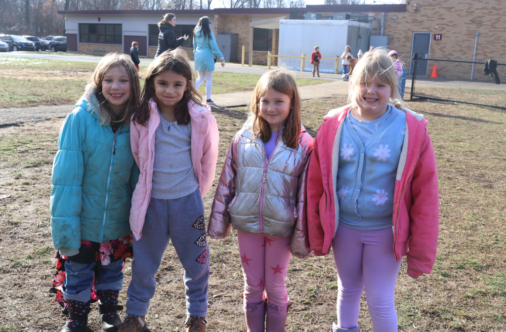 four little girls outside in winter wear at recess