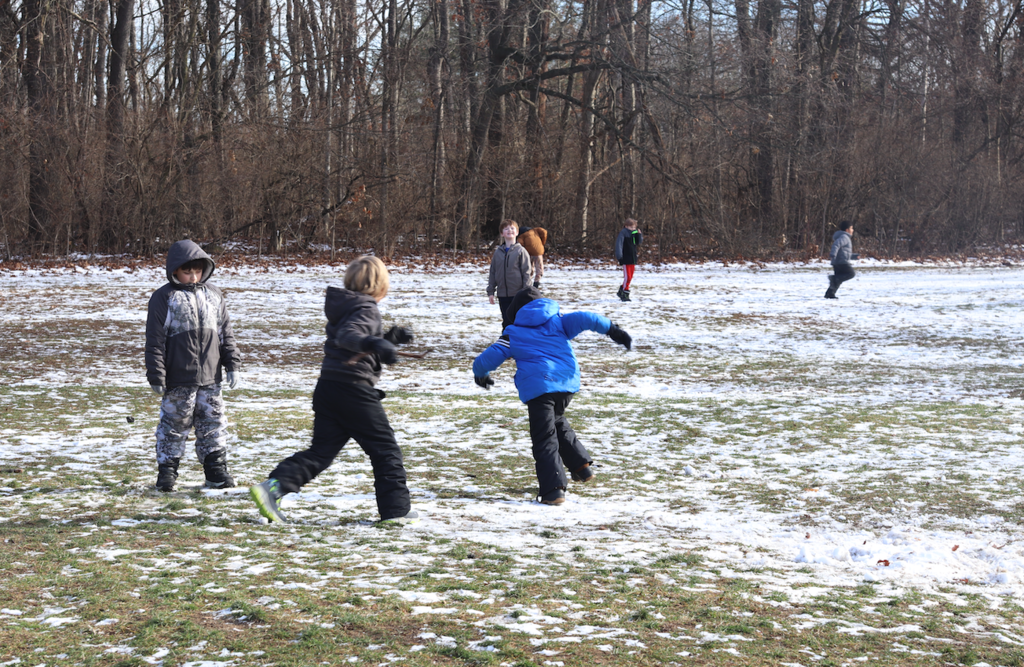 students running and playing soccer
