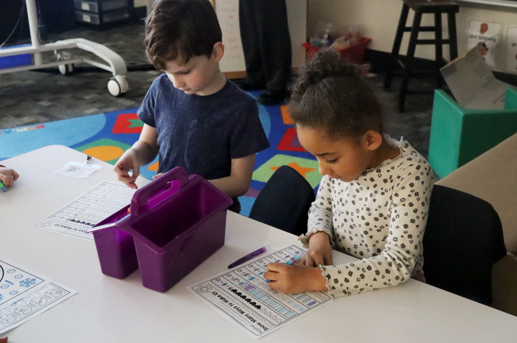 a little boy and a little girl doing a worksheet