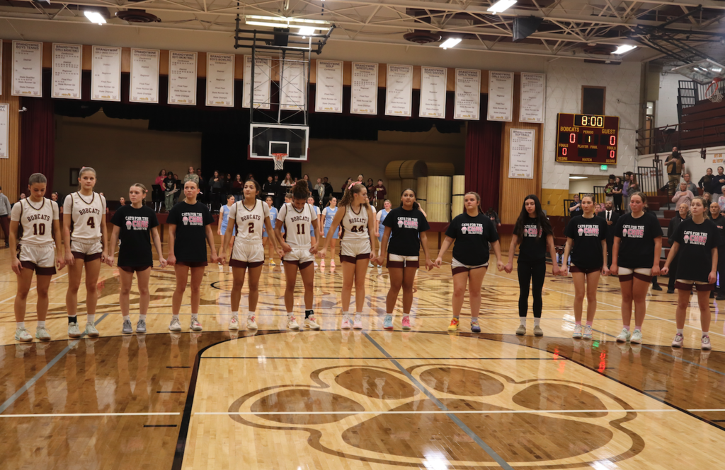 girls basketball team doing star spangled banner