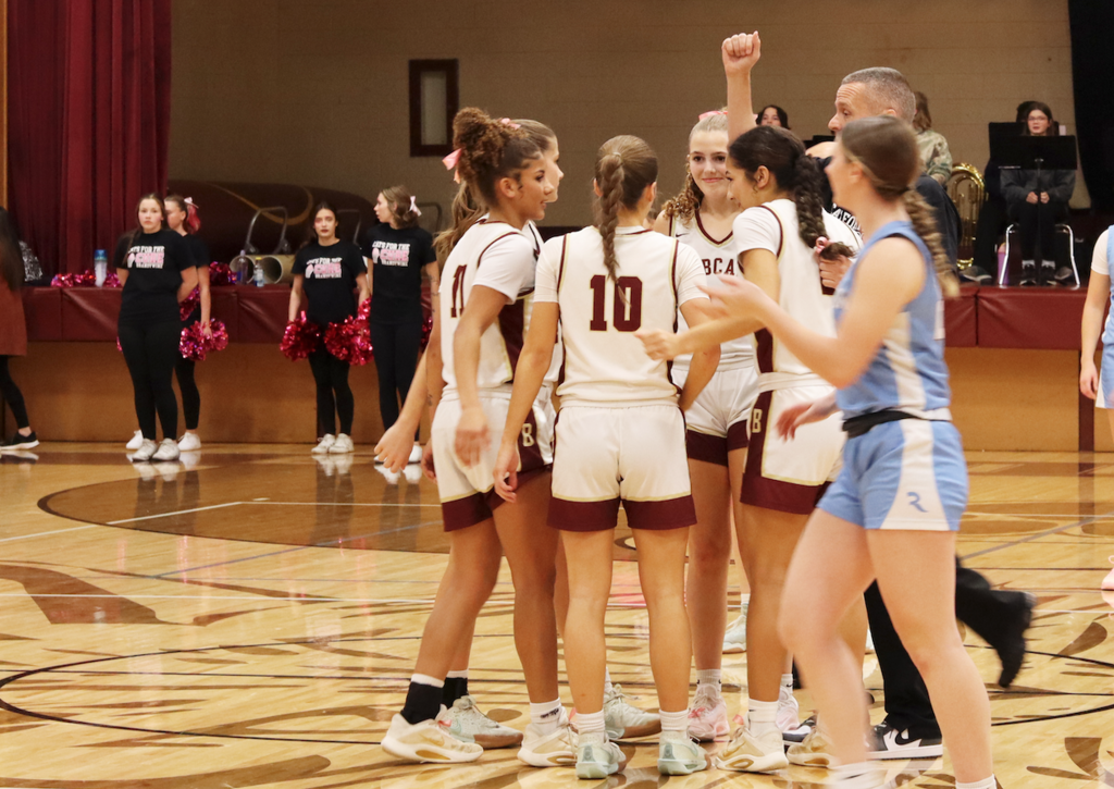 girls huddled with coach