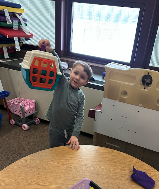 little boy holding a toy pet cage