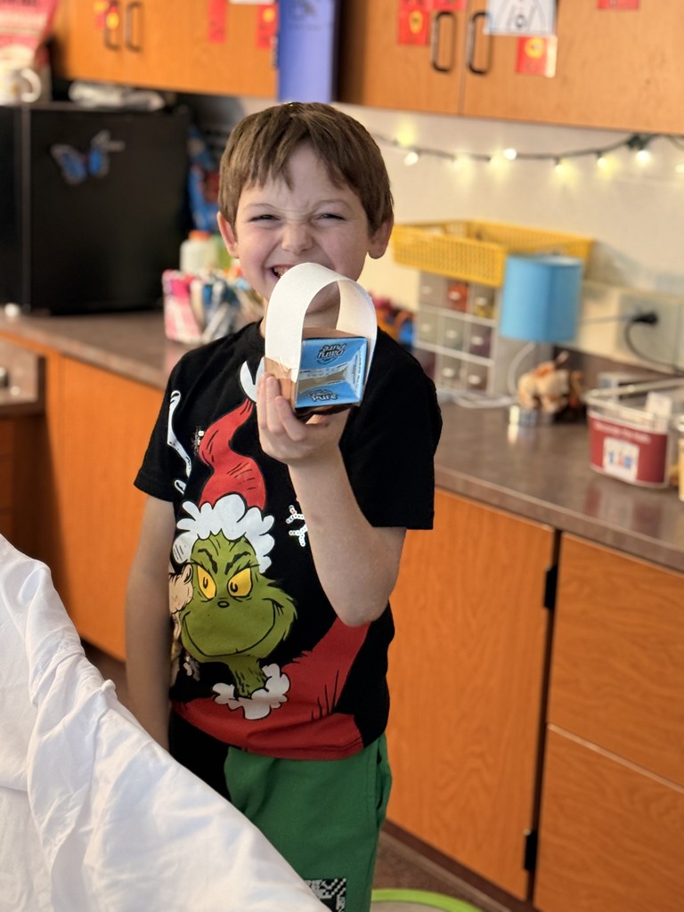 student making covered wagon from milk carton