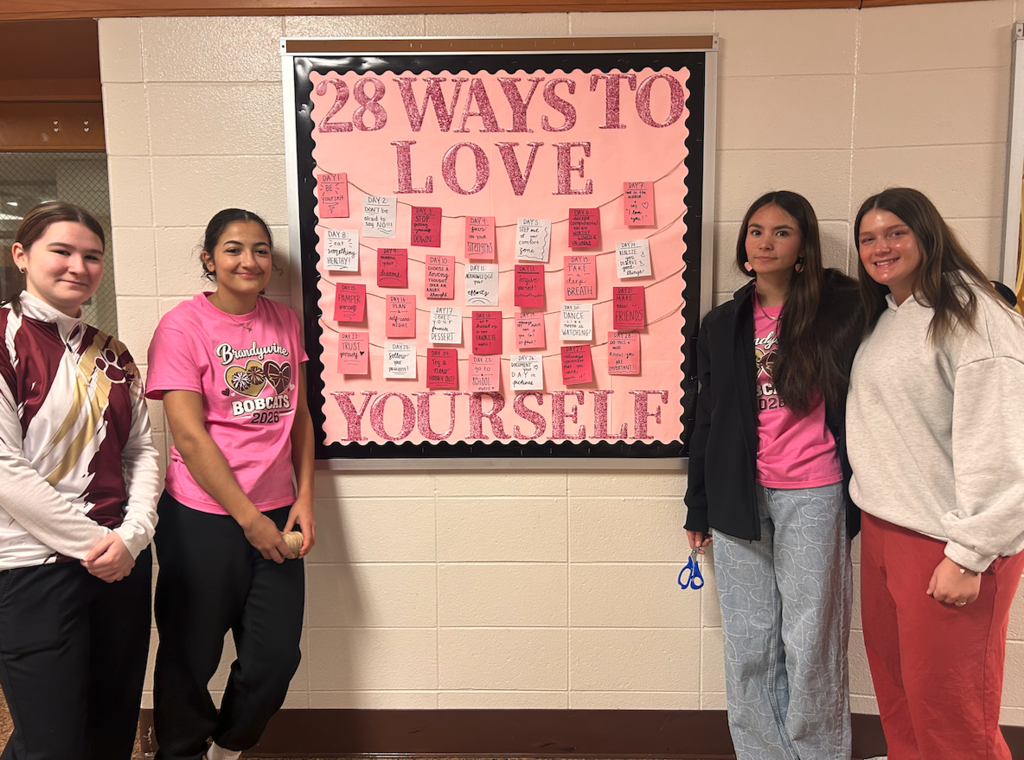 students from bobcat nation standing in front of bulletin board that says "28 ways to love yourself"