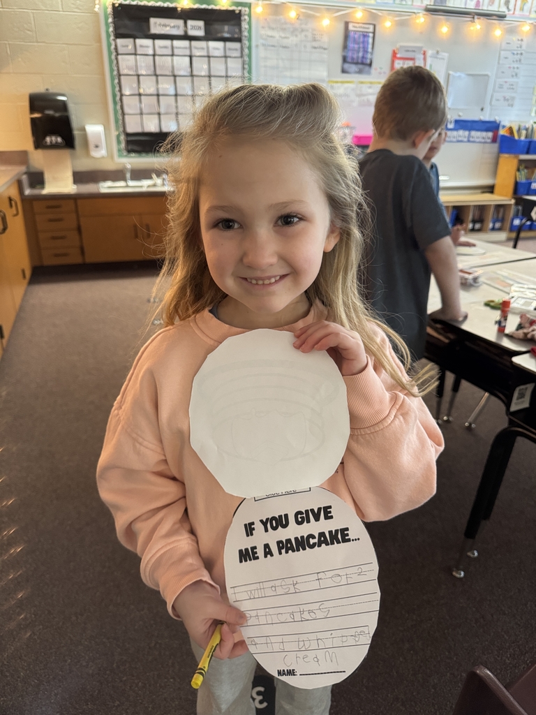 little girl holding picture of mini pancakes