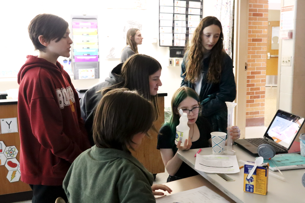 students pouring vinegar into a cup